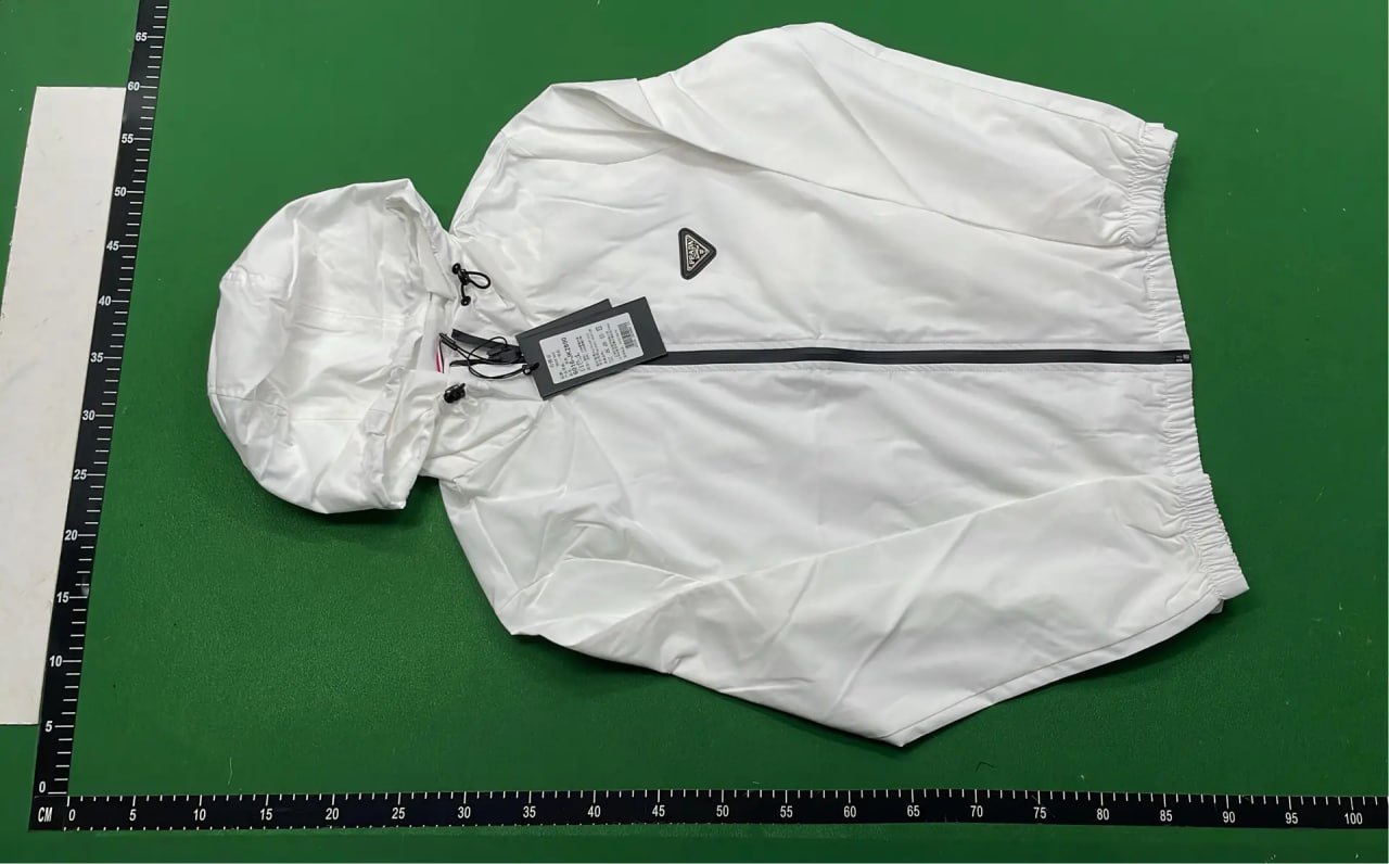 White windbreaker laid on a warehouse measurement board