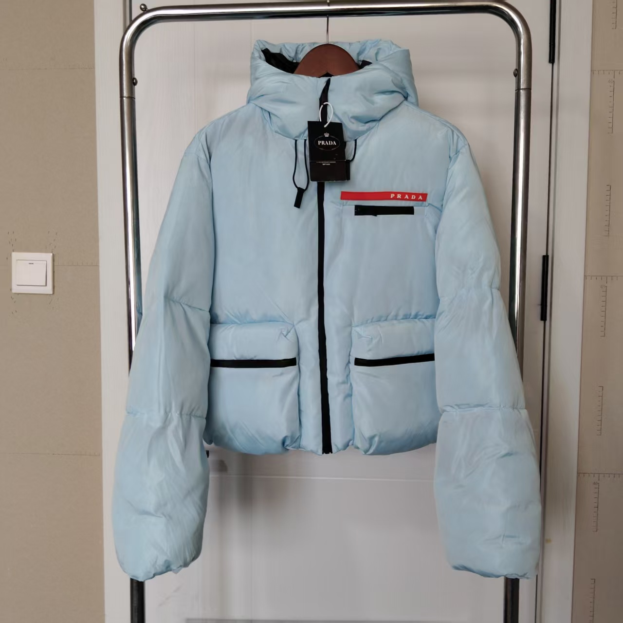 Short down jacket with a small blue lettered logo
